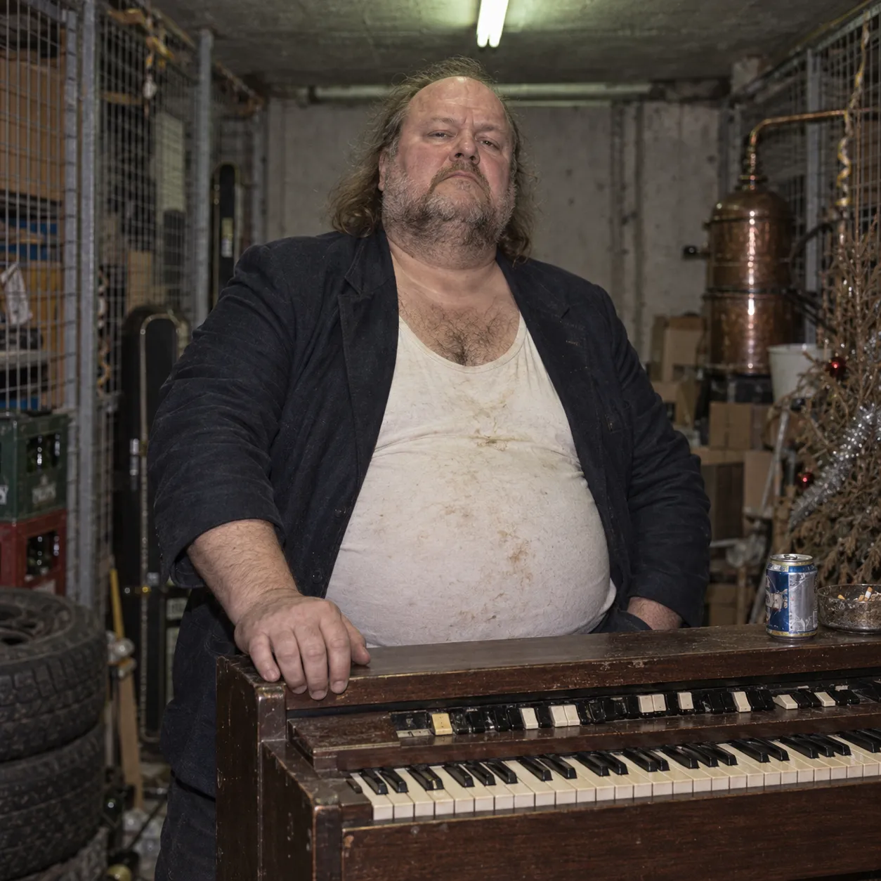 Bängt Hammar in a stained vest, leaning on his Hammond organ next to a beer can and an ashtray